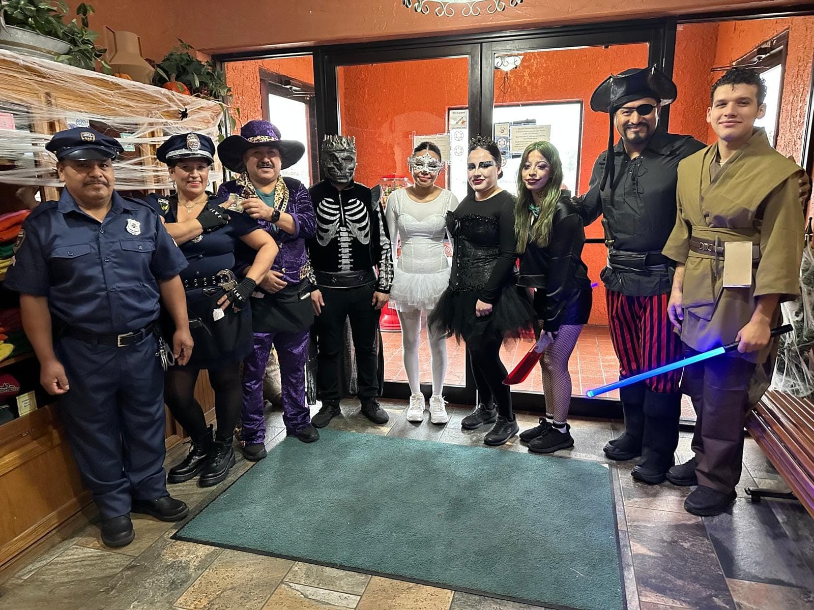 The staff of Abuelita Rosa's in Halloween costumes, posed together in the restaurant entryway